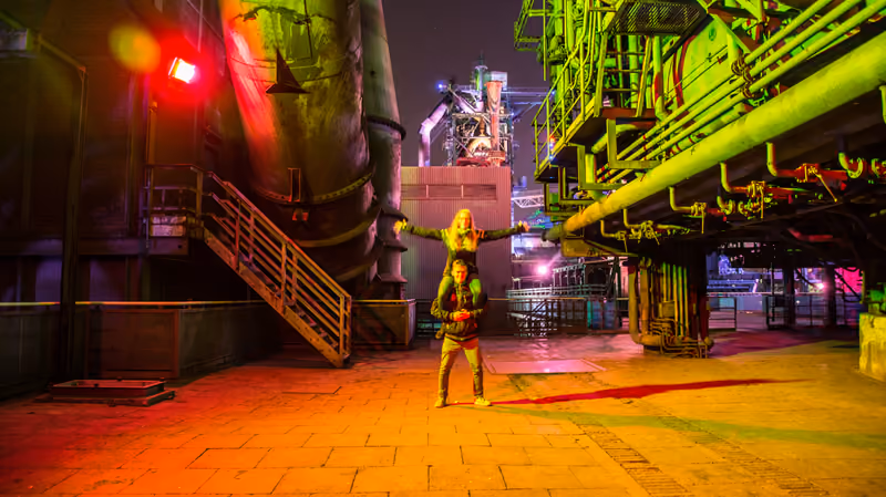 Person im bunt beleuchteten Landschaftspark Duisburg-Nord